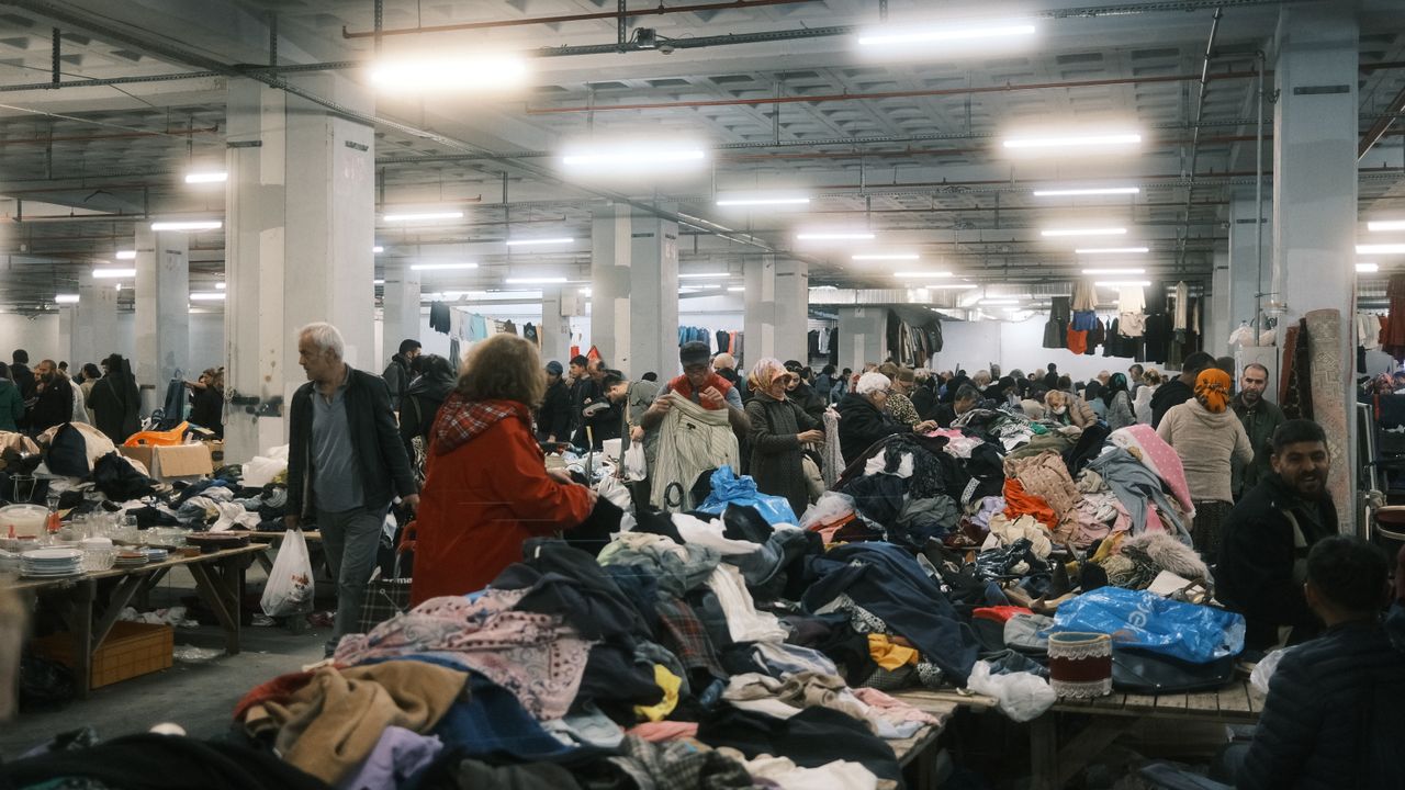 Vibrant indoor marketplace scene in Istanbul, featuring bustling crowds and colorful textiles.